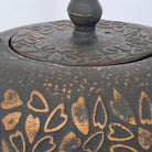 Decorative metal object with heart patterns on a white background